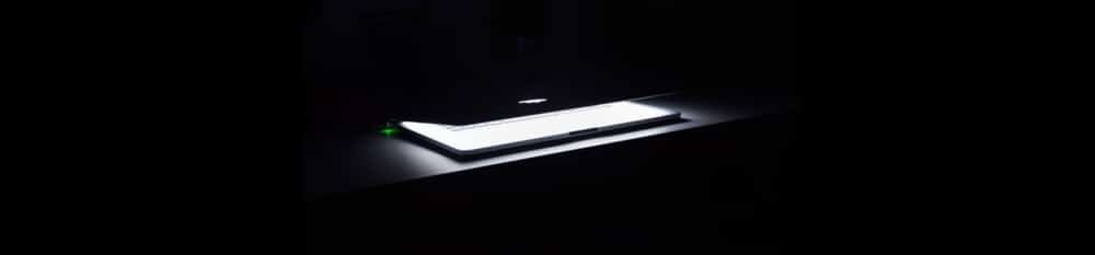 silver macbook air on a desk slightly opened to reveal a magical glow